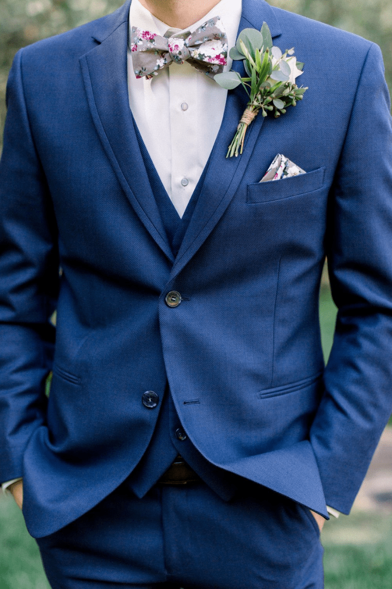 A dapper blue suit with a floral bow tie