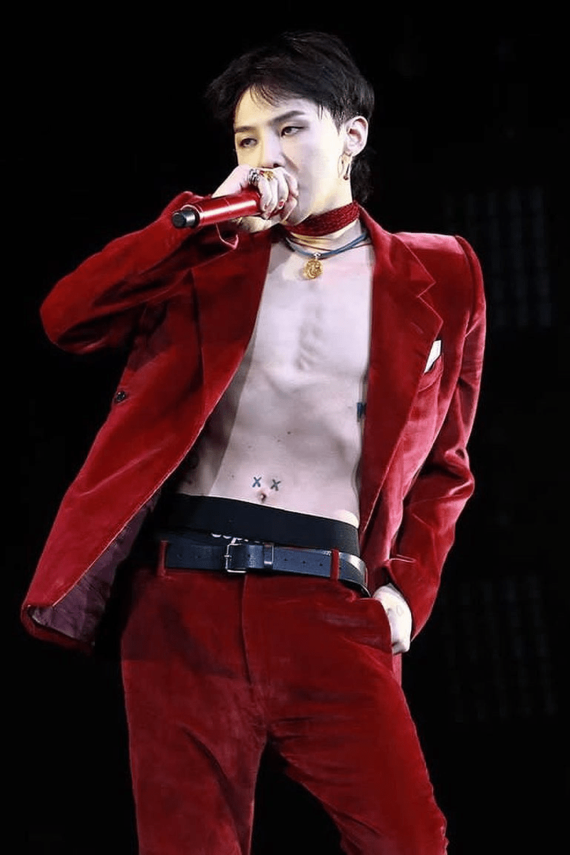 G-Dragon wearing a red velvet suit at a concert